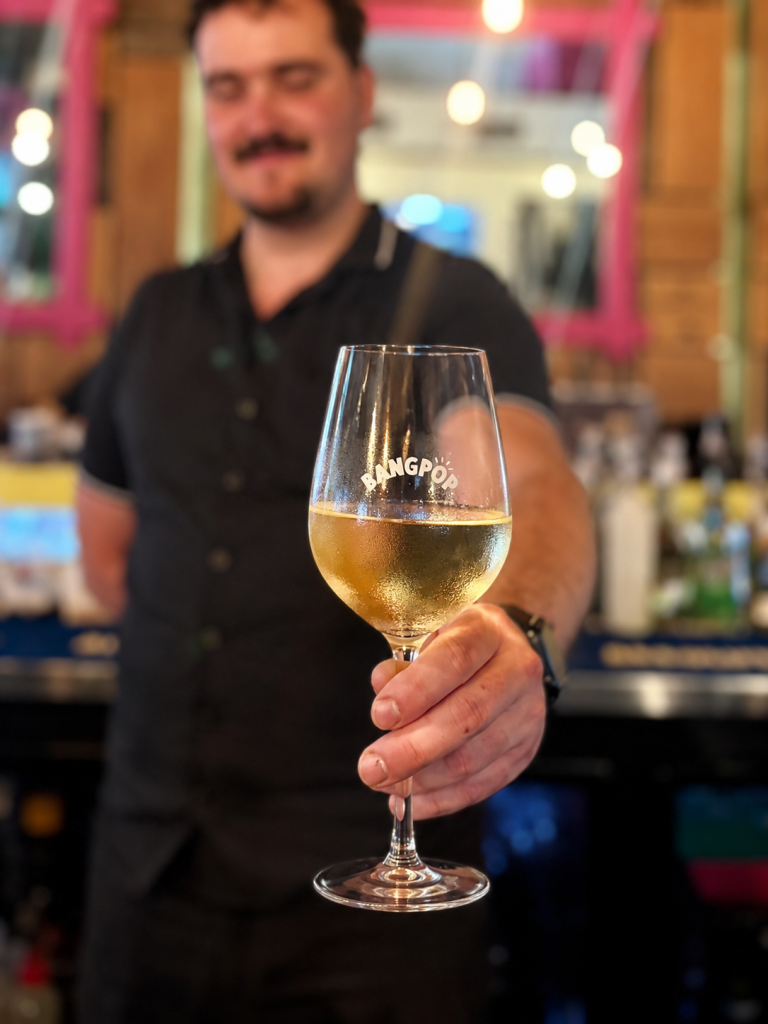 BangPop team member presenting a glass of wine