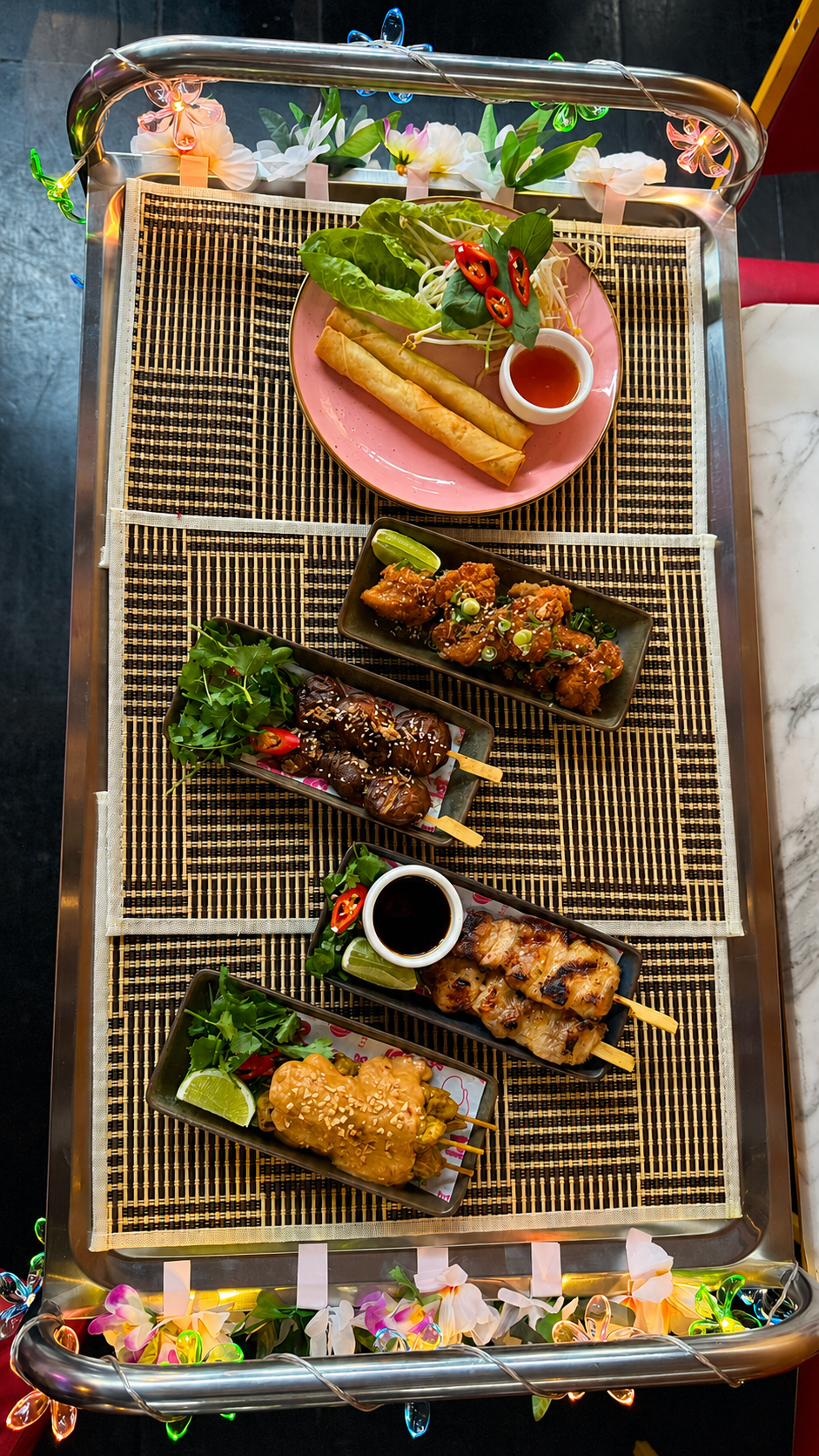 Overhead view of Thai Yum Cha dishes on BangPop’s decorated roving cart